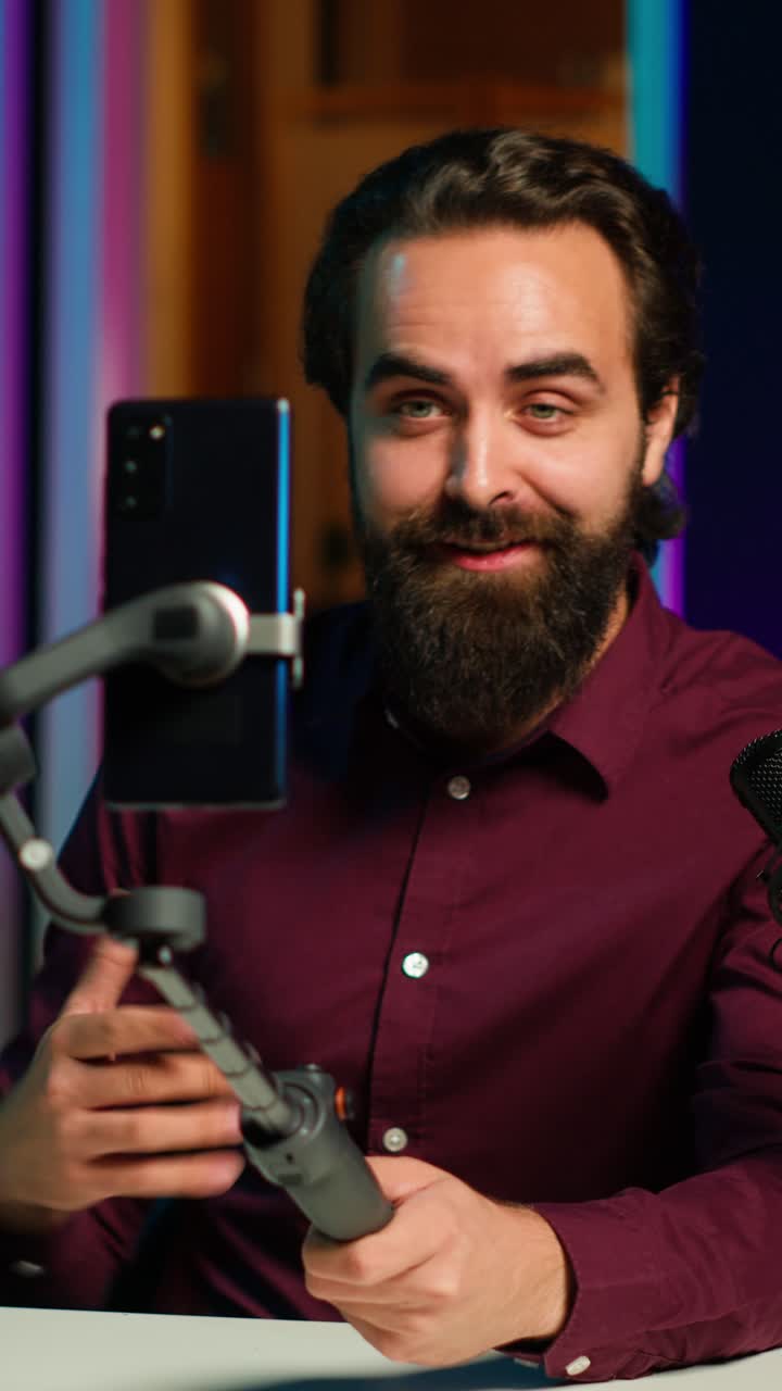 Video verticale Uomo espressivo usa lo smartphone su un selfie stick per girare un video