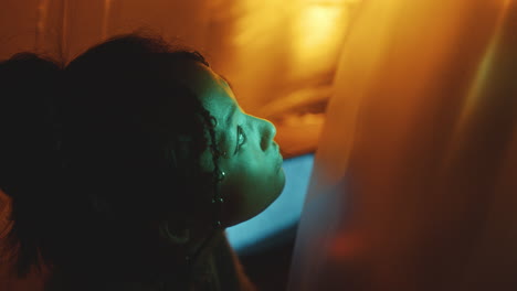 portrait of gorgeous asian girl in dark studio with neon light