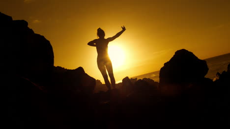 woman celebrating sunrise at the beach