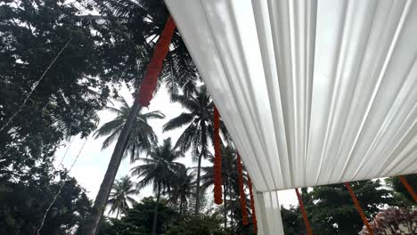 flower garlands hanging on ceiling of venue for hindu wedding in bengaluru, india. - low angle shot