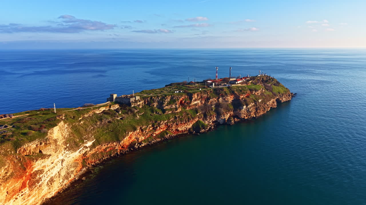 Vista panoramica di una zona costiera con scogliere, acqua e strutture industriali durante il giorno vicino all'oceano