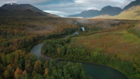 farms and houses are scattered through the forest-covered autumn valley