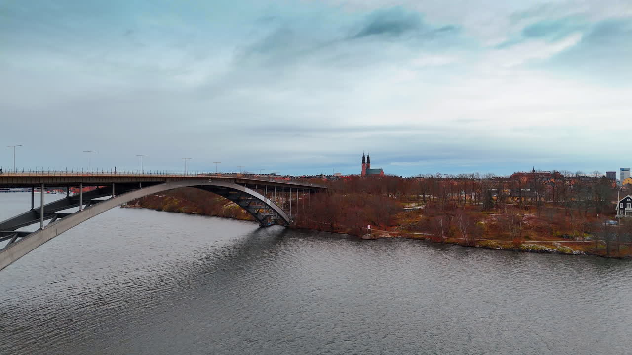 Sorgendo presso il grande Ponte Occidentale ad arco sopra il paesaggio acquatico grigio. Rivelando una vista sul famoso panorama del centro di Stoccolma, Svezia.