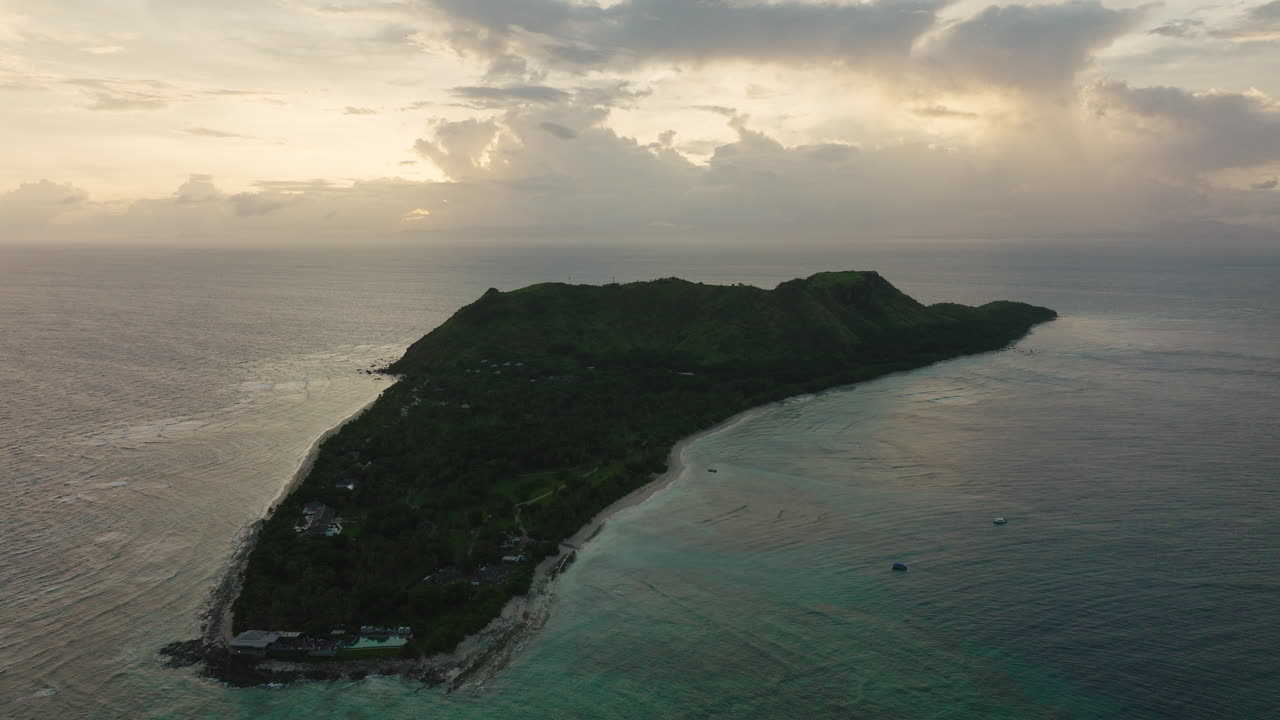 Lush island landscape with light cloud cover and turquoise sea
