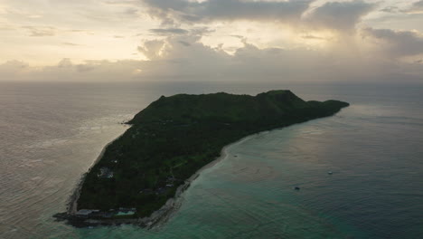 lush island landscape with light cloud cover and turquoise sea