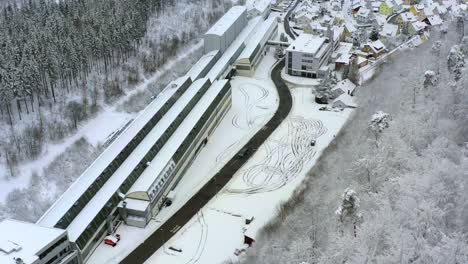 drifting car in the winter at a frozen parking lot, filmed from above by a drone