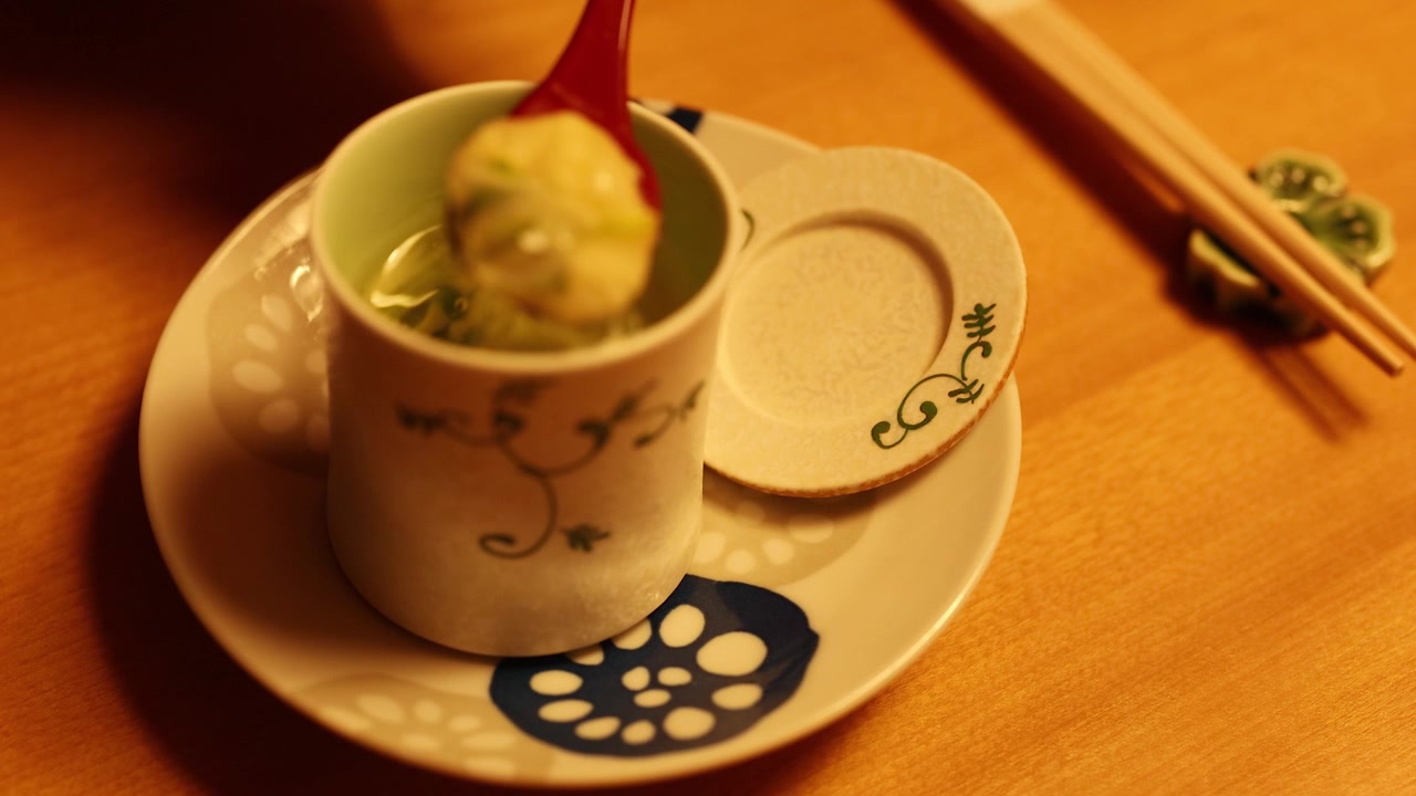 木製のテーブルに置かれた陶器のカップから、赤いスプーンが香り高い茶碗蒸しをすくっている。