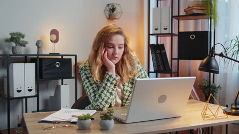 bored sleepy businesswoman worker working on laptop computer yawns leaning on hand at office desk