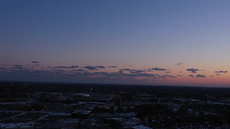 An-aerial-view-over-a-commercial-and-industrial-area-of-Long-Island,-NY-during-a-colorful-sunset