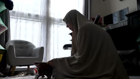 mujer musulmana con silueta preparándose para leer el corán en la sala de estar
