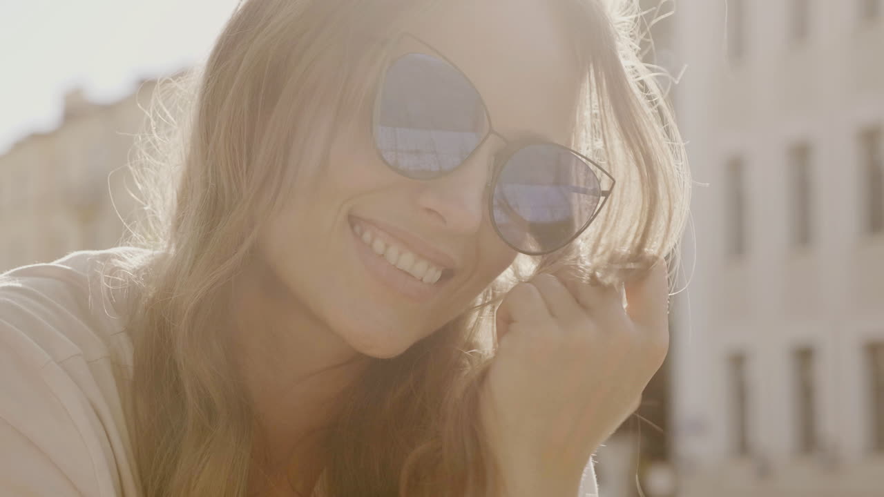 улыбающаяся женщина в солнцезащитных очках на открытом воздухе