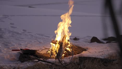 fogo queimando na neve enquanto acampando com uma panela