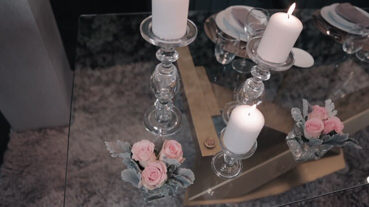Candele e rose su tavolo di vetro