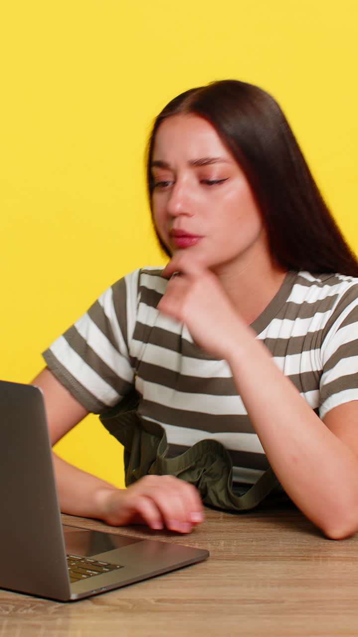 Woman at table focused reading difficult material on laptop concentrated on study or online course