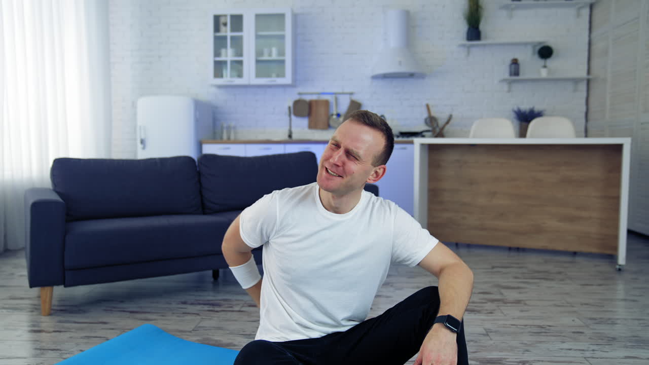 Man doing morning fitness at home. Young man resting after exercising at home
