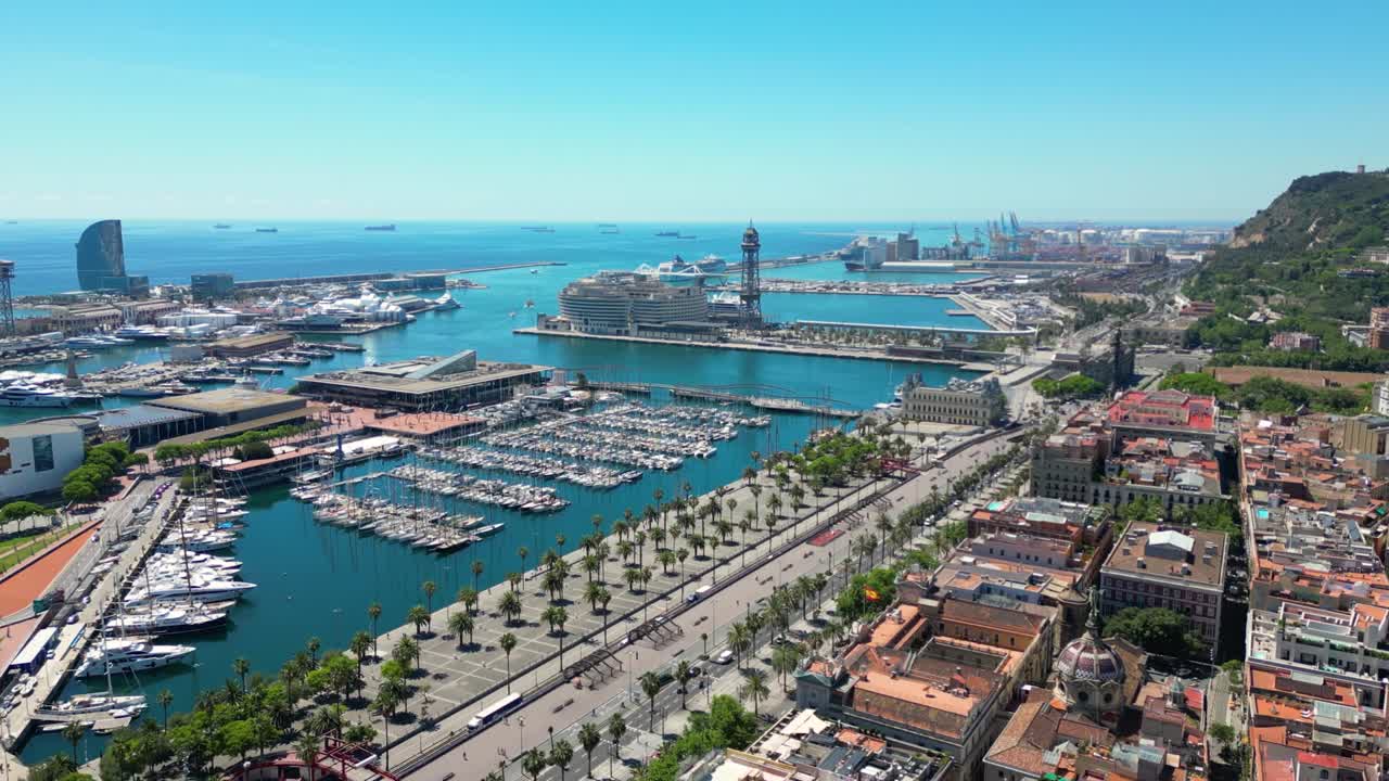 Aerial view over square Portal de la pau, and Port Vell marina and Columbus Monument during a sunny day in Barcelona, Catalonia, Spain