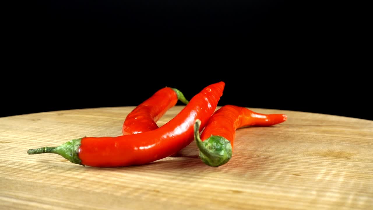 Pimenta em um fundo preto. Tábua de corte em movimento.