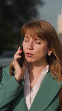 anxious woman talks on phone loudly. worried female person approaches car and ends conversation preparing to drive on blurred background closeup