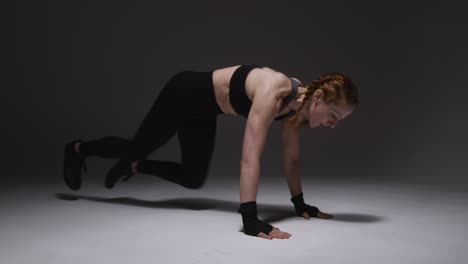 Studio-Shot-Of-Mature-Woman-Wearing-Gym-Fitness-Clothing-Doing-Mountain-Climber-Exercise-2