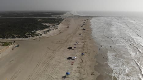 Sich-Auf-Den-Steg-Zu-Bewegen,-Am-Strand-über-Die-Wasserlinie-Fliegen,-Viele-Menschen-Schwimmen-Darunter