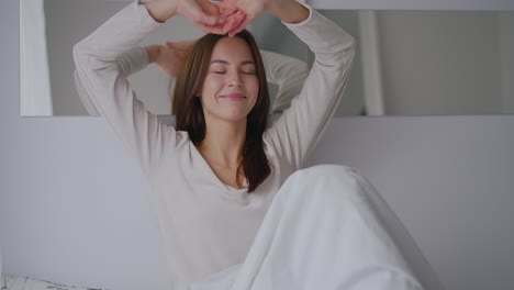 woman relaxing and stretching in bed