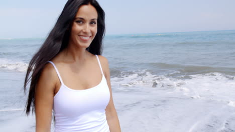 Woman-Walking-on-Beach-and-Smiling-at-Camera