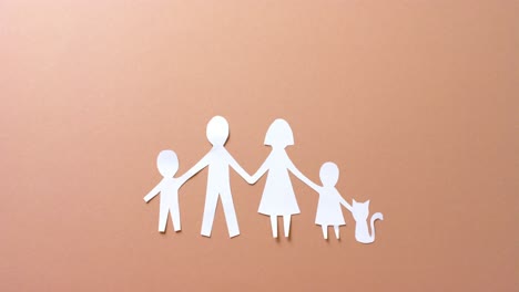 close up of family with cat made of white paper on beige background with copy space