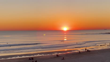 Aerial-footage---Jogger-on-a-lonely-sand-beach-runs-at-sunset-with-light-reflection-on-the-sea-surface-during-Sunset