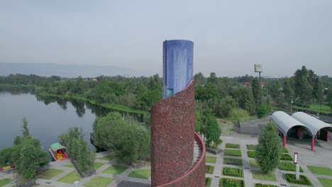 Imágenes-Orbitales-En-Foque-Alrededor-De-Escaleras-Frente-A-Un-Lago-Con-Vista-A-Trajineras-Y-Un-área-Natural-En-La-Ciudad-De-México