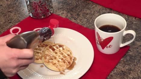 close up shot of a young adult woman putting syrup on a waffle at christmas time