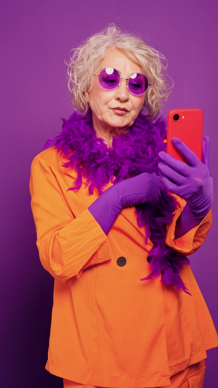 Stilfull eldre kvinne tar en selfie med smarttelefon.