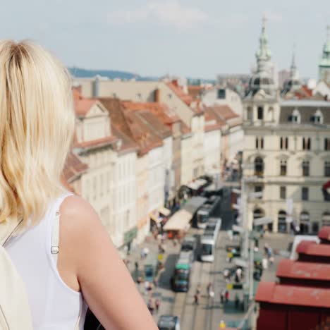 una joven turista está admirando la antigua ciudad europea desde una altura 1