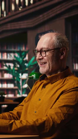 vertical video elderly actor in a library focusing on script reading and memorization