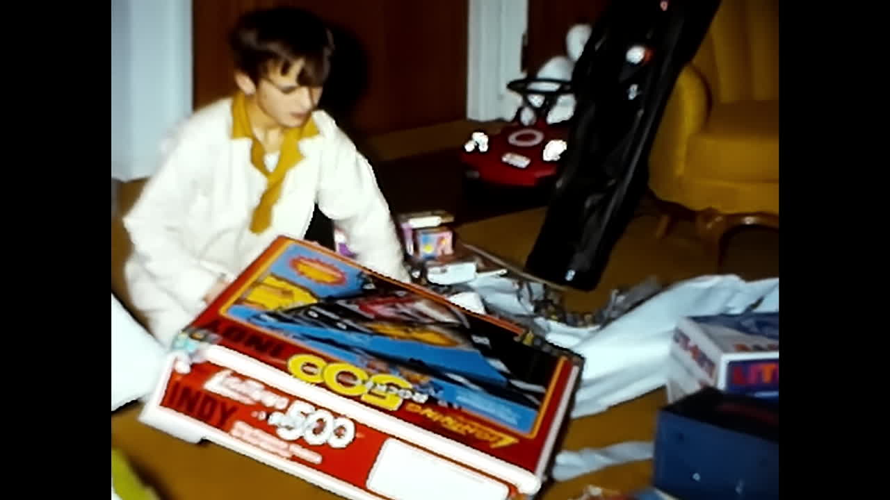 Young Boy Sitting Next to Bed. CIRCA USA - 1970s: A young boy sits on the floor beside a bed in a 1970s video archive from the USA.