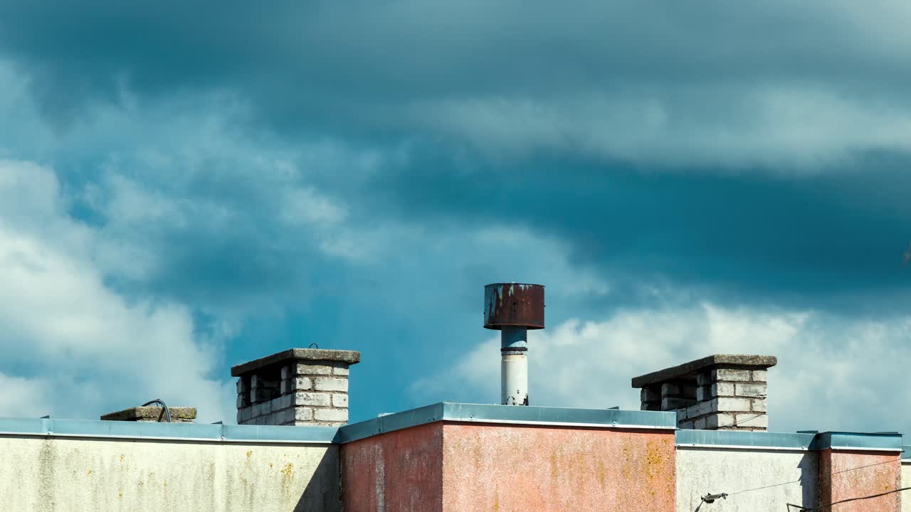 lapso de tiempo de hermosas nubes de tormenta de movimiento rápido blanco detrás de las chimeneas en el techo, el horizonte de la ciudad en un día soleado de verano, disparo medio lejano