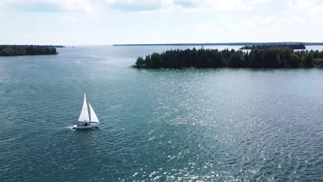 aerial of sailboat and forested islands in summer sun - hessel, michigan - lake huron