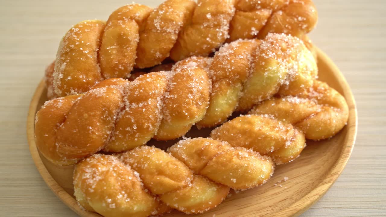 Donut de azúcar en forma de espiral sobre placa de madera