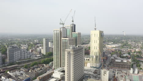 drone aerial shot of woking cityscape a town in england with high rise skyscrapers and cranes building works with drone tracking backwards