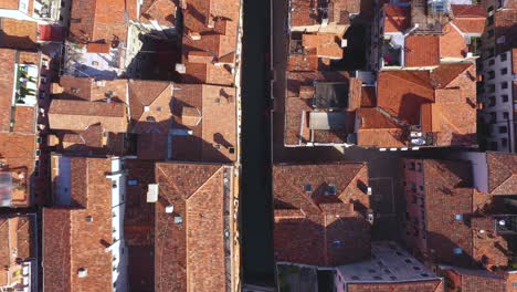 aerial view zooming into canal and roofs on a sunny day in venice in italy in 4k