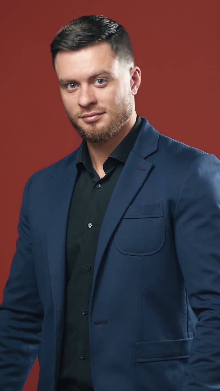 Young handsome businessman. Portrait of businessman standing on studio background. Vertical video