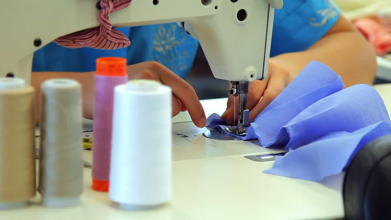 mano femenina trabajando en una máquina de coser industrial. concepto de la industria textil