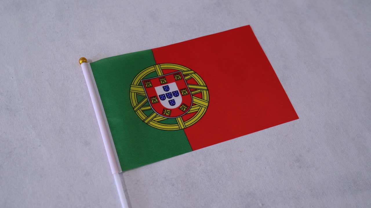 Närbild på Portugals flagga på vit bakgrund. Portugisiska nationalflaggan.