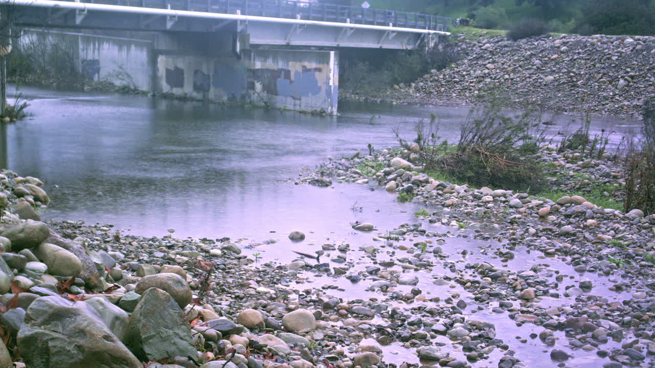 겨울 폭풍우가 강물에 비를 쏟으면서 범람하는 다리의 시간 경과