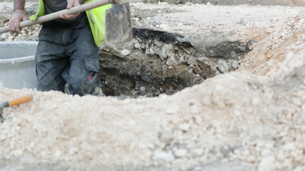 trabajador de la construcción desentierra junto a la tubería de hormigón en obras viales en leiria, portugal