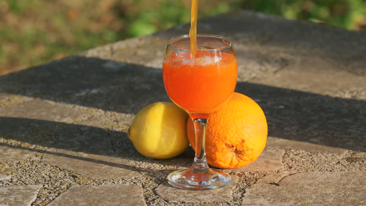 Slow motion of pouring orange juice into glass