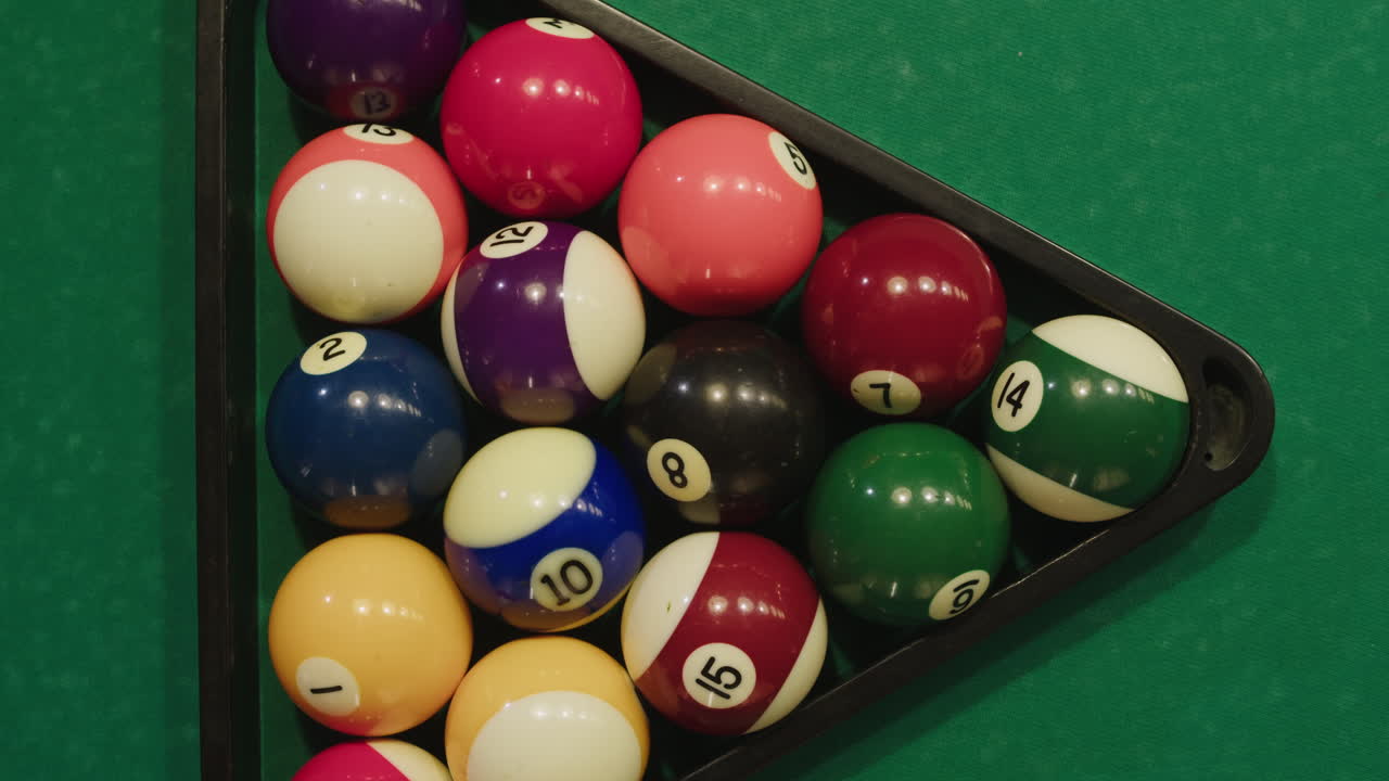 Beginning of game colorful pool balls top view on green billiards table for start to play. American pool, poule. Billiard balls with numbers on a pool table. Billiards team sport.High quality 4k footage