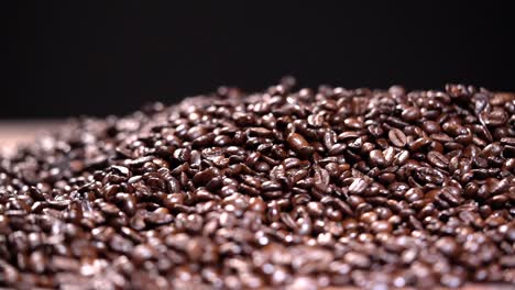 coffee beans falling in a pile hd slow motion on black background