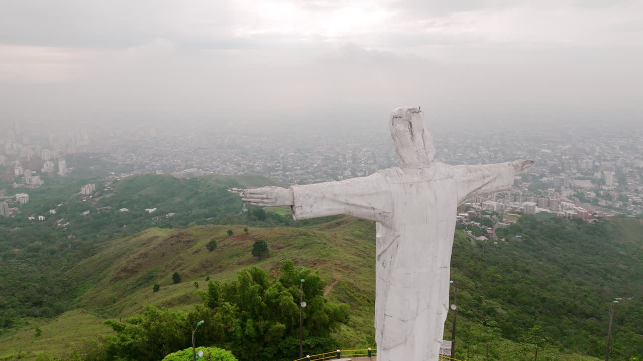 imágenes aéreas de rotación lenta de la estatua de cristo rey jesús en la cima de una montaña con torres de radio alrededor de cali, colombia