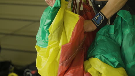 Adventure-seeing-sky-diver-adjusting-parachute-before-jump,close-up-shot