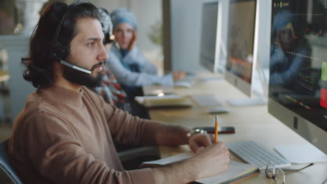 portrait of cheerful middle eastern businessman in headset in office